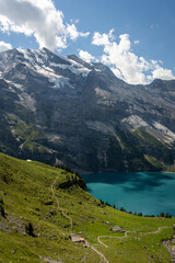 Famous Oeschinensee with Bluemlisalp mountain on a sunny summer day. Panorama of the azure lake Oeschinensee. Swiss alps, Kandersteg. Switzerland.