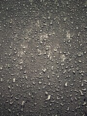 Water drops on black surface. Water droplets on dark background. Water droplets concept. Water drops on a black background. Banner with raindrops. Top view.