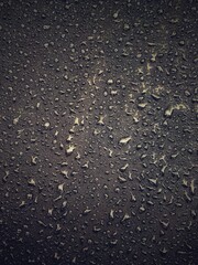 Water drops on black surface. Water droplets on dark background. Water droplets concept. Water drops on a black background. Banner with raindrops. Top view.