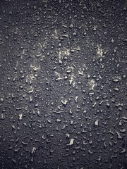 Water drops on black surface. Water droplets on dark background. Water droplets concept. Water drops on a black background. Banner with raindrops. Top view.