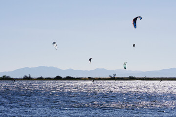 People kite surfing on the Mediterranean coast.