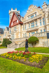 A woman visiting the Magdalena Palace next to the flowers in the city of Santander