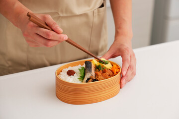 お母さんがキッチンでお弁当を作るシーン