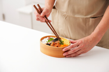 お母さんがキッチンでお弁当を作るシーン