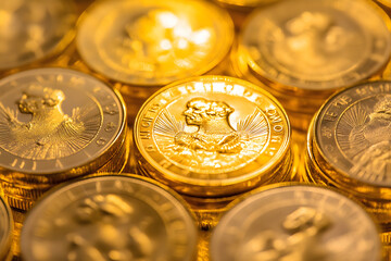 A close-up of gleaming gold coins stacked high, reflecting light and symbolizing wealth
