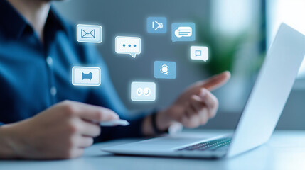 A businessman using a laptop with social media icons floating above.  The image represents communication, technology, and digital marketing.
