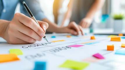 Close-up of hands working on a project with colorful sticky notes and a pen.