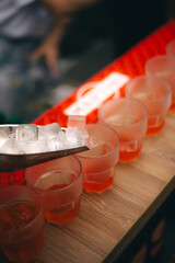 Ice cubes are poured into cocktails