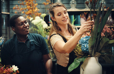 Small business, florist and smile at flower shop for floral arrangement with teaching, learning and training. People, manager and happy with employee at green store as suppliers with teamwork