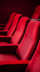 Obraz premium Red cinema or theater seats with armrests arranged in rows for watching movies. The movie screen is obscured from view, without people