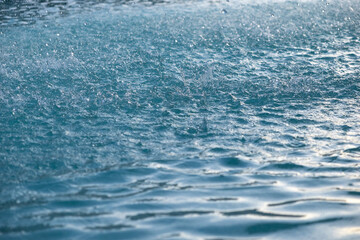 Close-up of water droplets falling into the water. Rain on the sea