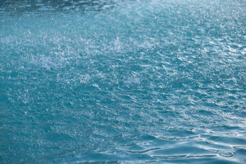 Close-up of water droplets falling into the water. Rain on the sea