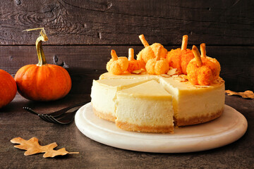 Fall cheesecake dessert with delicious pumpkin cheese balls. Side view table scene with a dark...