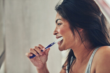 Fototapeta premium Home, profile or woman brushing teeth for wellness, grooming routine or morning breath. Face, girl or healthy female person cleaning mouth for dental care or oral hygiene in house bathroom in Mexico