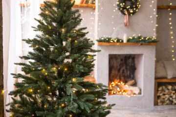 The interior of the Scandinavian-style living room, decorated for the Christmas holidays. Christmas tree next to the fireplace.
