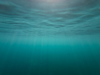 Underwater photography, bright rays of sun penetrate the water, Cote d'Azur.
