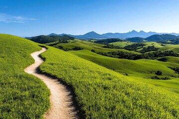A trail winding through a grassy hillside, with rolling hills and distant mountains visible in the background