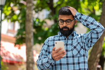 Sad Indian bearded man use smartphone typing browsing, fail loses lottery casino application, bad...