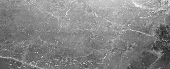 A grey stone wall with cracks and holes. The wall is old and worn, with a rough texture