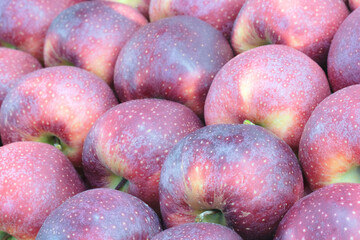 A bunch of red apples with a few green spots. The apples are shiny and look fresh. Concept of abundance and freshness