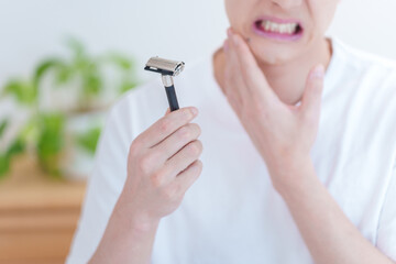 髭剃りで剃刀負けをする男性