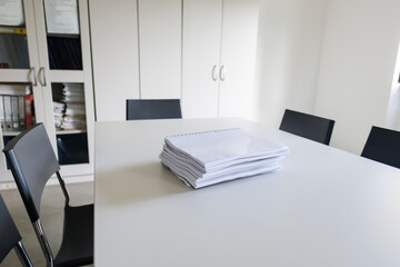 stacked documents on a conference table in a modern office