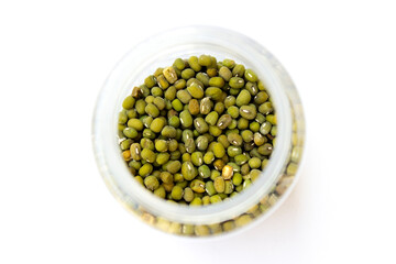 Mung beans in the glass jar isolated on the white background. Mung beans are packed with vitamins and minerals essential for various bodily functions, including immune support and energy metabolism.