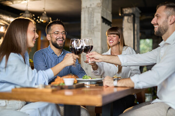 Team of happy business colleagues toasting with wine in a restaurant.