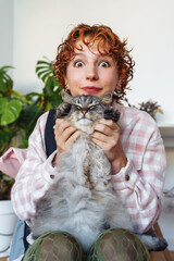 portrait of red-haired attractive young woman with grey big cat