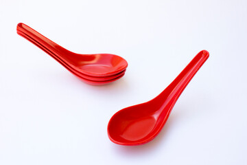 Some red chinese spoon on the white background. Most Chinese soup spoons are made from ceramics, but they can also be found in materials like stainless steel and melamine.