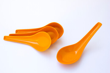 Some red chinese spoon on the white background. The spoon has higher sides compared to Western soup spoons, allowing it to hold more liquid.