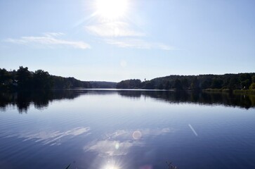 landscape lake pond blue sky sun shining in water reflection