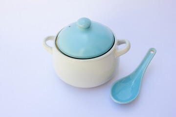 A porridge bowl and porridge spoon isolated on a white background. The tableware is made of porcelain and is colored blue and white.