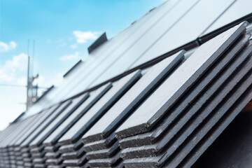 Exploring Intricate Details of Freshly Installed Slate Roof Under Bright Blue Sky