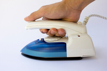 A blue and white electric iron in hand isolated on white background.