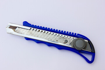 Sliding Mechanism: The utility knife features a sliding mechanism, controlled by a grey circular...