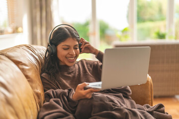 Naklejka premium Cozy Evening at Home With Music and Laughter While Working on Laptop in Warm, Inviting Space