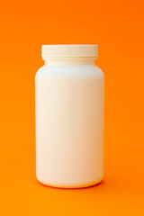 A white plastic bottle. This bottle is commonly used to store vitamins or medicines such as capsules or pills.