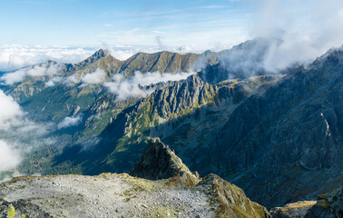 Mountain ridges and puffy clouds between them, beautiful autumn landscape in the Tatra Mountains.