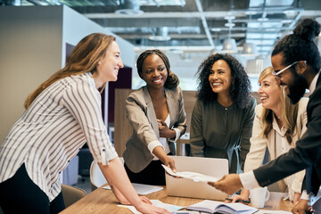 Meeting, paperwork and business people in huddle for teamwork, strategy or partnership. Laptop, smile or employees giving documents in office planning for feedback review, group or project briefing