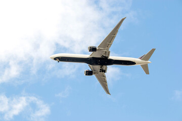 White passenger airplane flying in the sky amazing clouds in the background - Travel by air transport. High quality photo
