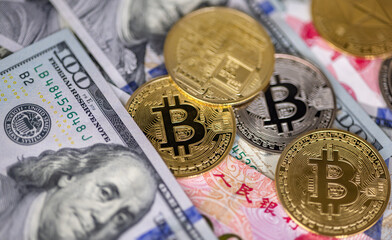 gold and silver bitcoins on bank notes background