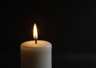 a white candle on a black background