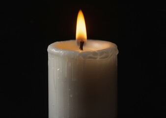 a white candle on a black background