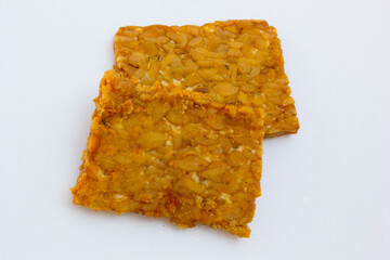 Fried Tempeh Texture: A detailed photograph of fried tempeh, focusing on the crispy outer layer and the firm, nutty interior. This image is perfect for illustrating articles or recipes that feature te