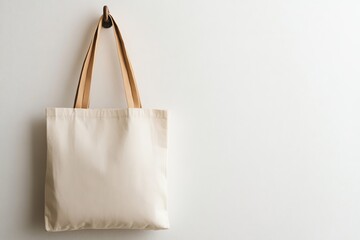 White Canvas Tote Bag Hanging on a Hook Against a White Wall