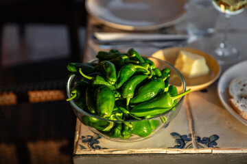 Frische ungebratene Tapas Klassiker Pimientos de Padron in einer Glasschüssel