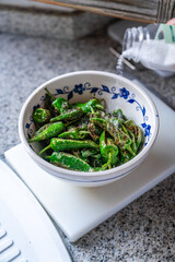 Tapas Klassiker Gebratene Pimientos de Padron in einer weisen Schüssel