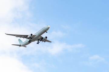 White passenger airplane flying in the sky amazing clouds in the background - Travel by air transport. High quality photo
