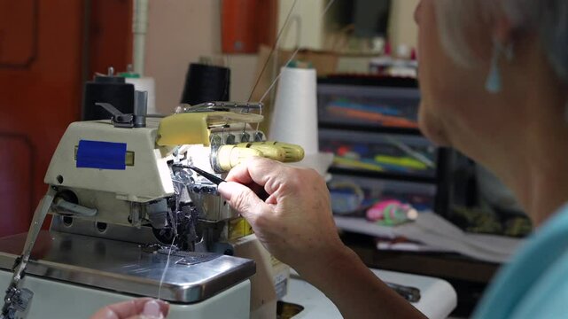 Mujer madura enebrando una maquina de coser para poder empezar a usarla